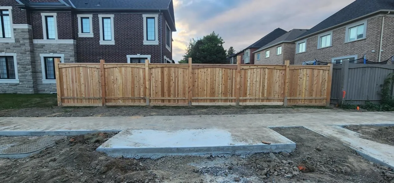 Cedar privacy fence lining a new-build property at dusk