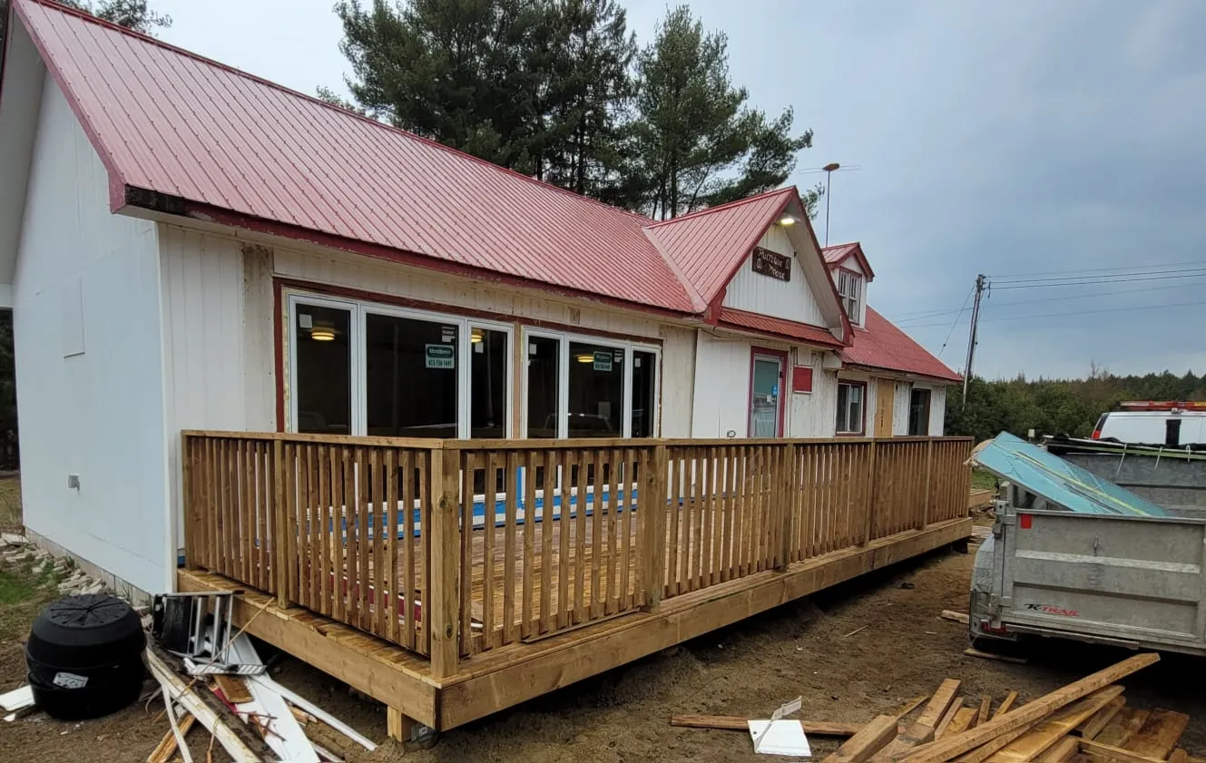 Pressure-treated wood deck wrapping a rural building