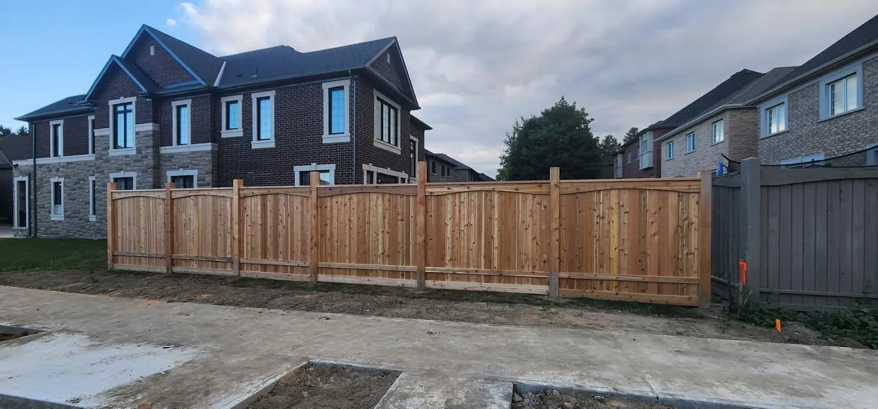 Cedar privacy fence with scalloped panels at a new home