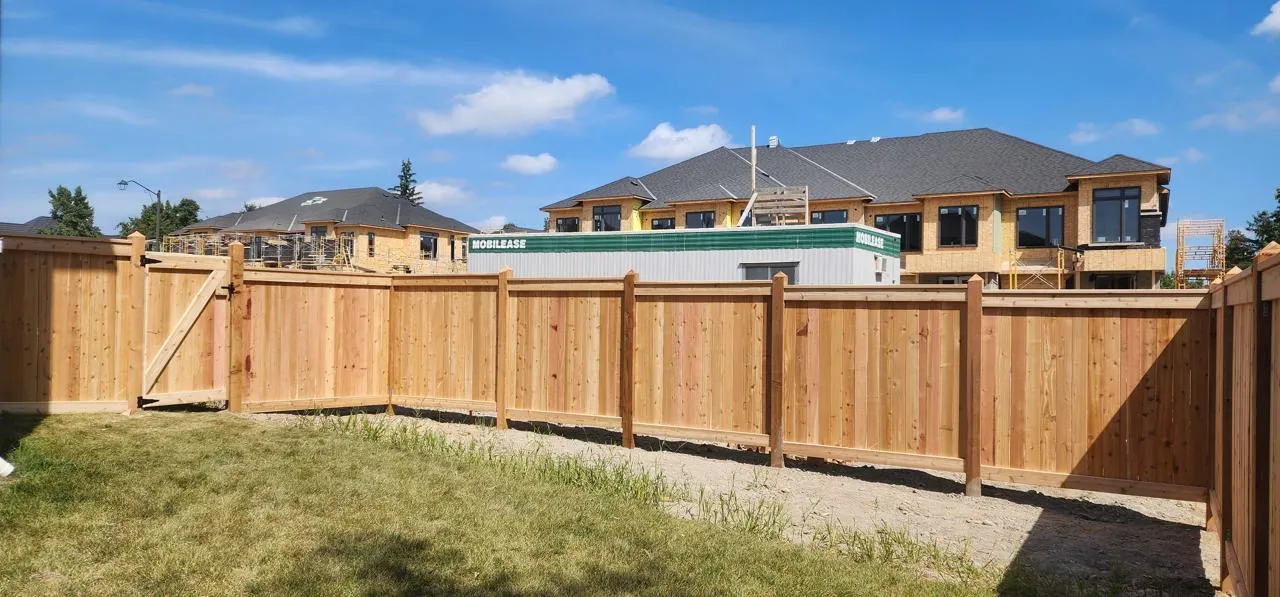 Cedar privacy fence and gate at an active construction site