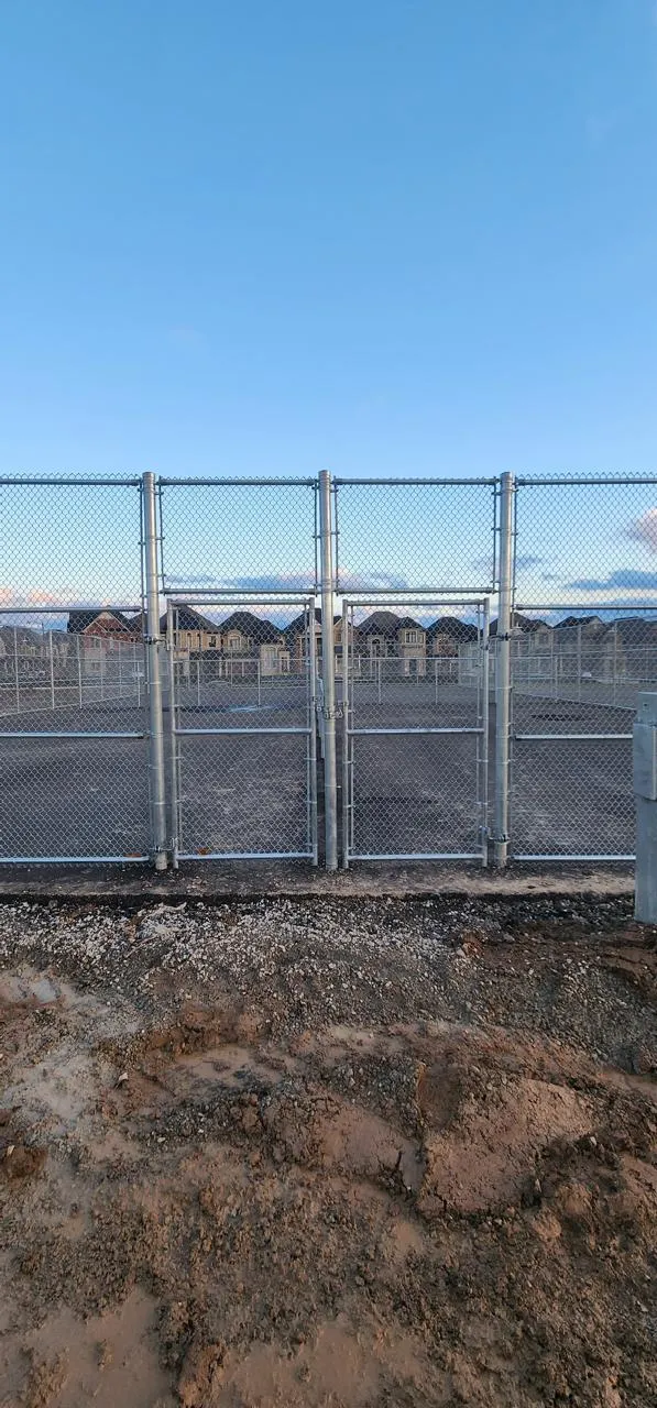 Galvanized chain link gate on a field at dusk